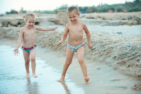 两个快乐的孩子们在沙滩上打了一天时间