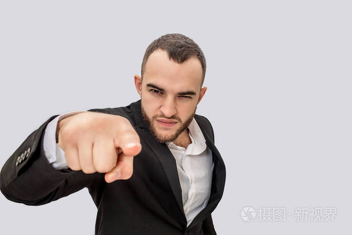 穿着西装的严肃年轻人在镜头前指着人.他退缩了隔离在