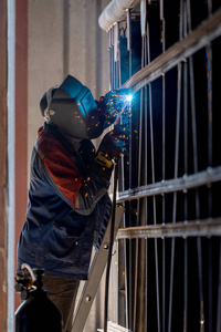 工业工人在工厂的弧焊钢结构。