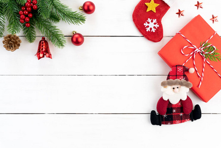 圣诞节背景概念。 顶部的圣诞绿色和红色礼品盒与云杉枝，松果，红色浆果和铃铛在白色的木制背景。
