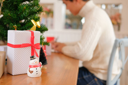 男人穿着奶油毛衣，写圣诞信，贺卡，节日祝福，圣诞装饰。