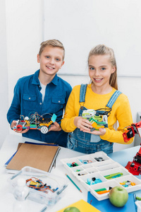 微笑的孩子抱着电动机器人在stem教育班