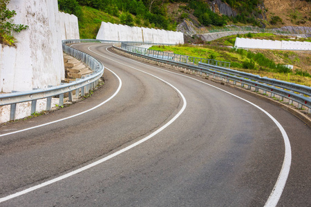 弯曲道路的景色。 在山路上开车。 山上的沥青路。 空路背景