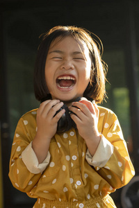 亚洲儿童手拿耳机的滑稽表情