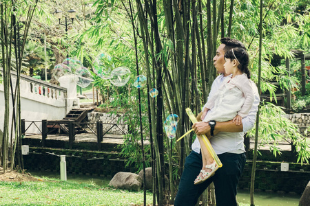 家庭观念，年轻的父亲和他的女儿，在公共公园里享受着面对面的乐趣。