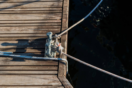 帆船港口桥梁上的游艇细节绳索和系泊双交叉护栏。木码头