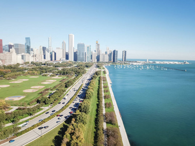 芝加哥市中心的顶部景色高大的天际线，繁忙的交通在美国公路41from格兰特公园。 宁静的密歇根湖和沿着湖岸的绿树驱动着一排停靠的