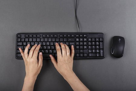 女性手在黑色电脑键盘上。 商业规划。 与办公室设备合作