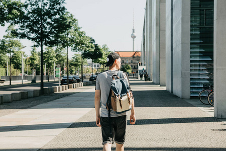 一位背着背包的游客走在柏林的一条街道上