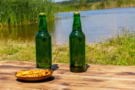 在河边的木桌上放两瓶啤酒