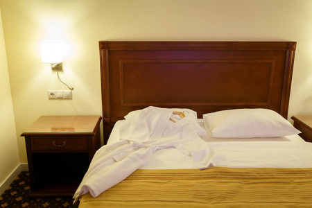 白色浴袍躺在酒店房间的大双人床上