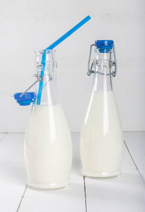 旧的复古风格的瓶子，新鲜牛奶在格朗格白色木桌上。