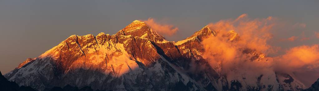 傍晚日落，红彩色的珠穆朗玛峰和努普特山南岩面，美丽的云从孔德村，孔布谷，Solukhumbu，尼泊尔，喜马拉雅山