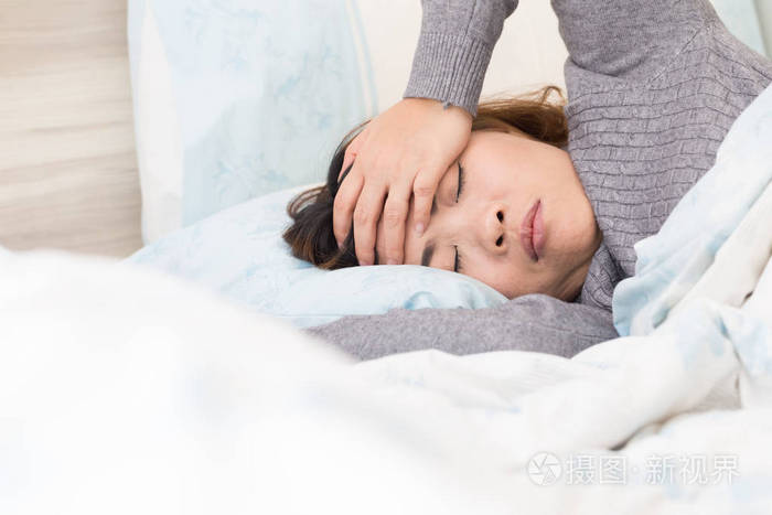 亚洲女人头痛躺在床上