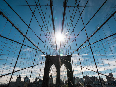 著名的布鲁克林大桥的轮廓, 它的顶峰的太阳闪耀着它的柱子。纽约最著名的象征之一