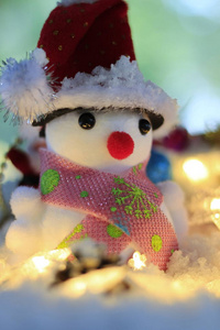 雪地背景模糊上有圣诞装饰品的雪人。