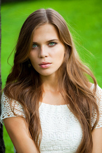 年轻美丽女子的肖像，绿色背景下的夏日自然