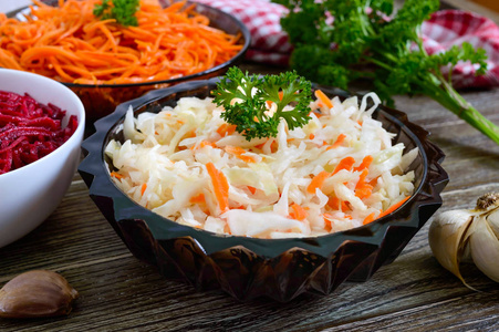 新鲜蔬菜沙拉卷心菜胡萝卜甜菜。 韩国辣沙拉在木制桌子上的碗里。 维生素菜单。 纯素菜。