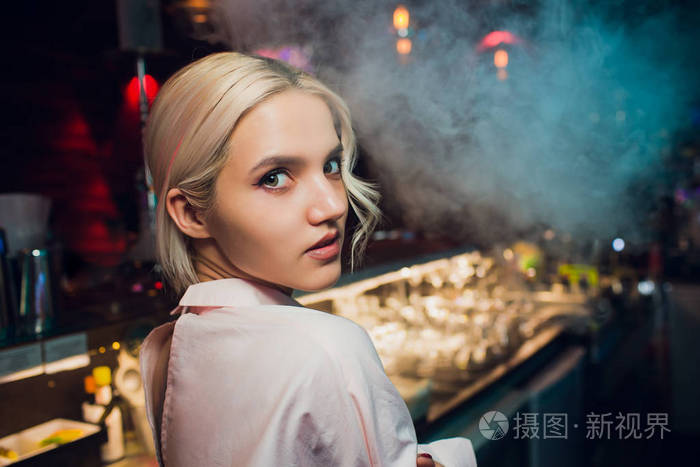 一个女孩的肖像在一个夜酒吧柜台后面