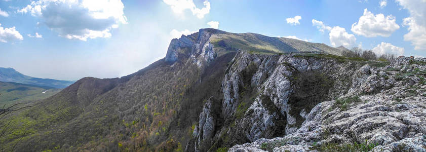 春天岩石山岭和森林覆盖坡度的全景。克里米亚山区