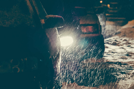 道路上的冬季天气状况。 夜间暴风雪期间，汽车在城市街道上行驶