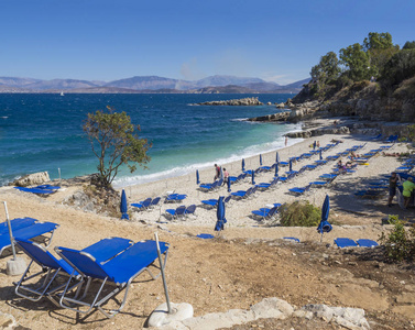 在希腊科孚岛 kassiopi 的小路上可以看到 kassiopi 湾的巴达里亚白色沙滩和游客。