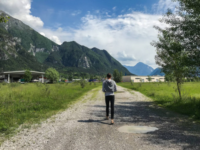 步行在山地轨道道路上的人的后视图