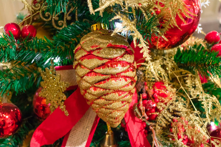 绿色松树枝和红色松果金。 珠宝中的圣诞树关闭。