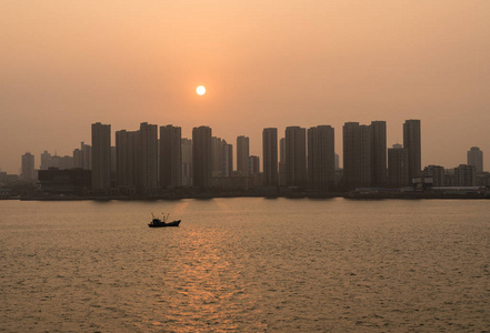 太阳在中国青岛高大的城市天际线后面升起