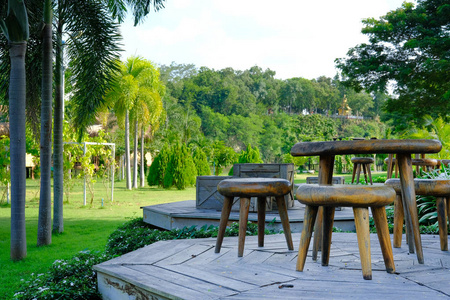 靠近花园的露台阳台露台上的木椅桌。 放松生活方式概念