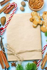 蓝色桌面上空白笔记本圣诞饼干和糖果罐的顶部视图
