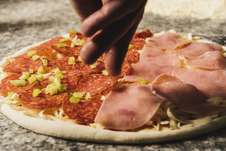 用火腿和意大利香肠准备披萨