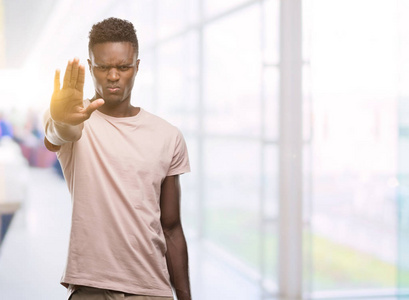 年轻的非裔美国人，张开手做停止标志，严肃自信的表情防御手势