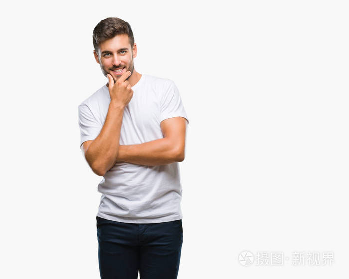 年轻的英俊男子在孤立的背景上,自信地看着相机,微笑着交叉的手臂和