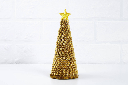 DIY金色圣诞树从珠子花环。 照片上的指南如何用你自己的手用纸板星星热胶和珠子制作一棵装饰圣诞树。 手工制作。
