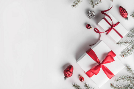 圣诞礼品盒白色背景与杉树枝松果红色装饰。 圣诞节和新年快乐主题。 平躺顶部视图空间文本