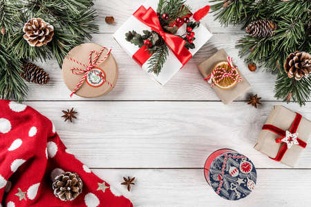 创意布局由圣诞杉枝松果礼品圣诞毛衣白色木制背景。 圣诞节和新年主题。 平躺式顶部视图