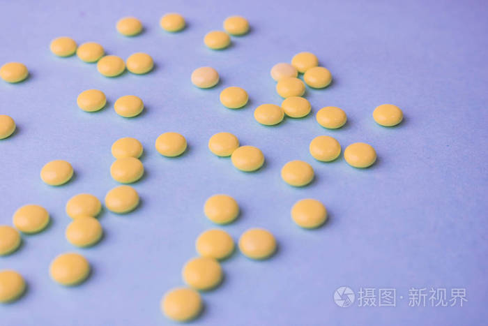 小黄色橙色美丽的医学药效圆丸, 维生素, 药物, 抗生素上的蓝色背景