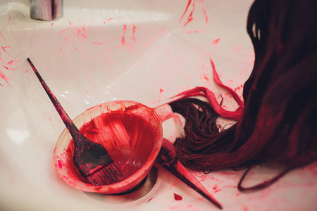 美容师垂死的女人的头发。在美容院的女孩