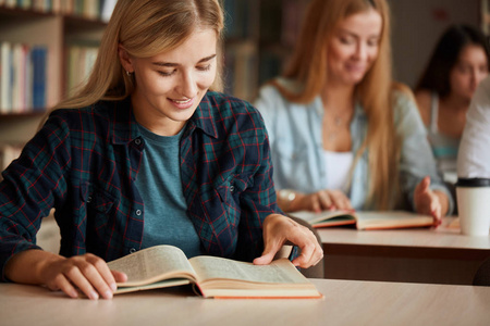 金发快乐美丽的女学生在室内上大学课程