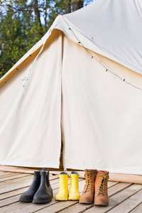 特写镜头的闪闪发光的钟帐篷与鞋。家庭露营的概念