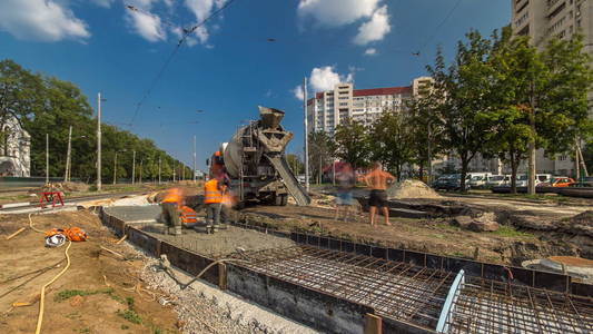 混凝土工程的道路建设，许多工人在统一和搅拌机时间推移。 重建电车轨道