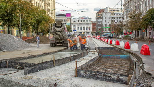 混凝土工程的道路建设，许多工人在统一和搅拌机时间推移。 重建电车轨道