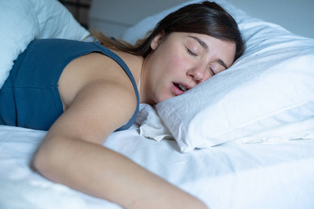 一个疲惫的女人在床上打鼾的画像