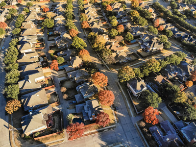 鸟瞰计划单位发展郊区达拉斯德克萨斯美国秋季季节。 天桥住宅区，有一排独栋住宅和花园，五颜六色的落叶
