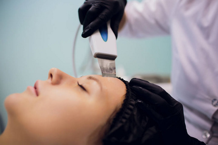 美容办公室专业超声波设备接受清洁治疗的妇女