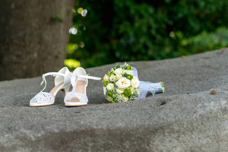 新娘花束和花边鞋在灰色的石头特写镜头