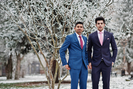 两个优雅的印度时尚男式西装模特在冬天摆姿势。