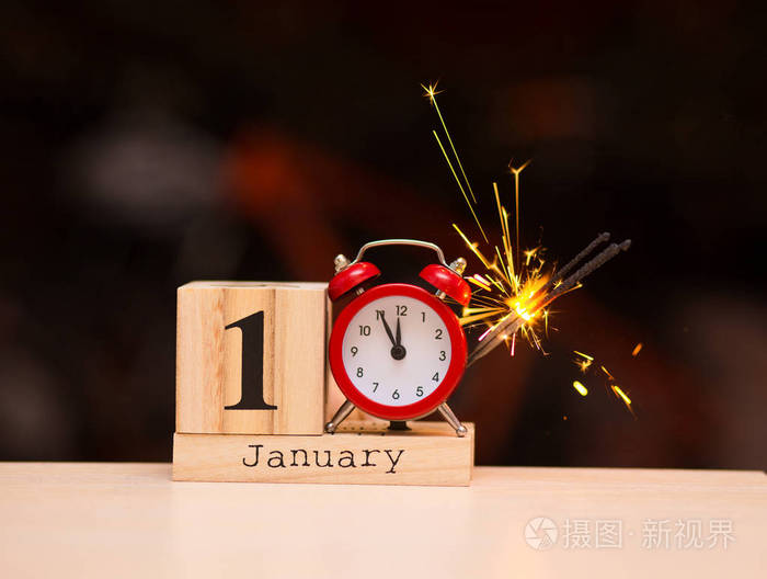 一月一日 一月份的第一天设置在带有黑暗背景的木制日历上.