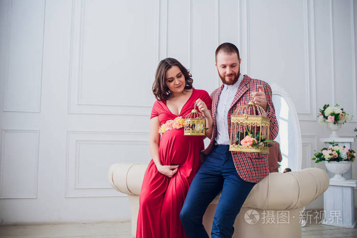 照片 美丽的年轻夫妇在爱.孕妇和她的丈夫坐在家里.